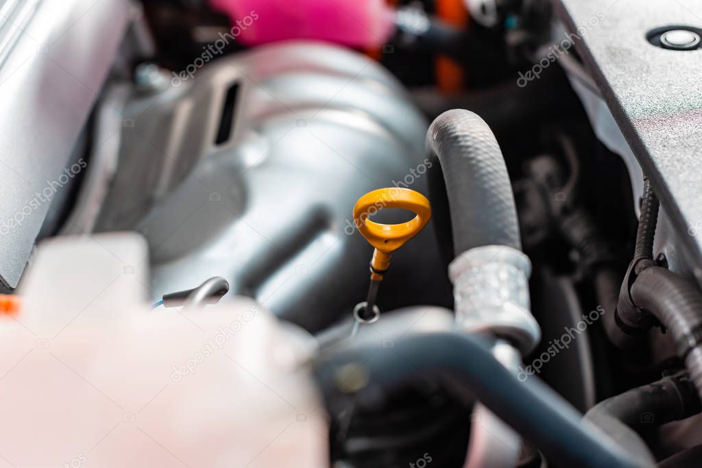 selective focus of engine oil dipstick in motor compartment