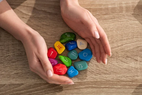 Cropped View Girl Holding Colorful Stones Zodiac Signs Wooden Table — Stock Photo, Image