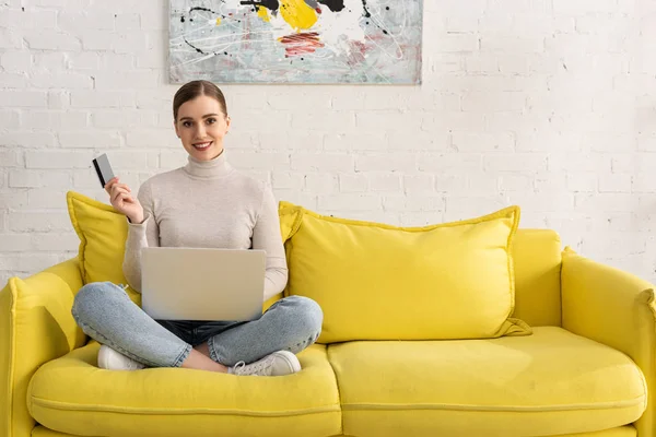 Menina Bonita Sorrindo Para Câmera Enquanto Segurando Cartão Crédito Laptop — Fotografia de Stock