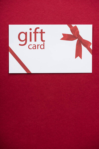 Top view of white gift card on red surface