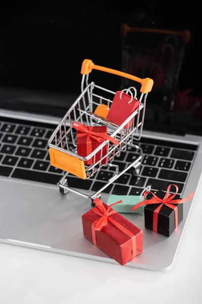 Fokus Selektif Kotak Hadiah Mainan Gerobak Pada Laptop Atas Meja — Stok Foto
