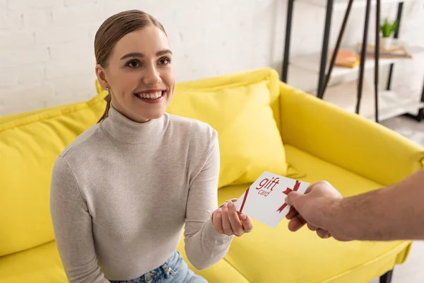 Man Giving Gift Card Smiling Girlfriend Couch — Stock Photo, Image