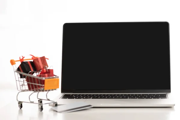 Boş Ekranlı Dizüstü Bilgisayar Beyaz Arka Plandaki Masada Oyuncak Hediyeli — Stok fotoğraf