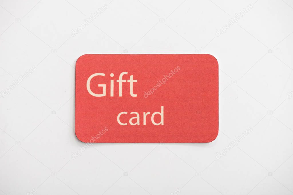 Top view of red gift card on white surface
