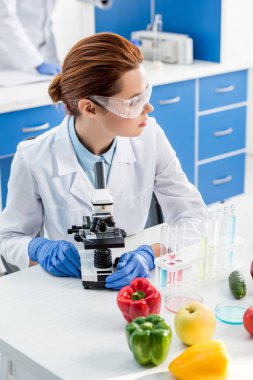 Moleküler beslenme uzmanı masada oturuyor ve laboratuvara bakıyor. 