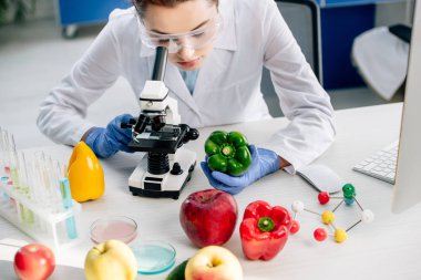 cropped view of molecular nutritionist using microscope in lab  clipart