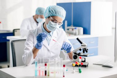 selective focus of genetic consultant doing dna test in lab  clipart