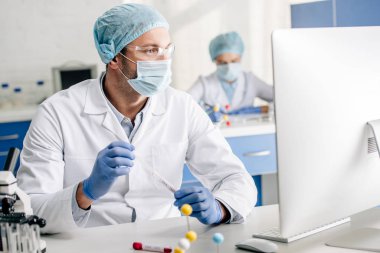 DNA testi yapan ve laboratuvardaki bilgisayara bakan seçici genetik danışman. 