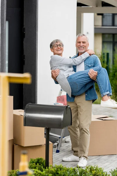 Uomo Maturo Tenendo Donna Sorridente Occhiali Vicino Alla Nuova Casa — Foto Stock