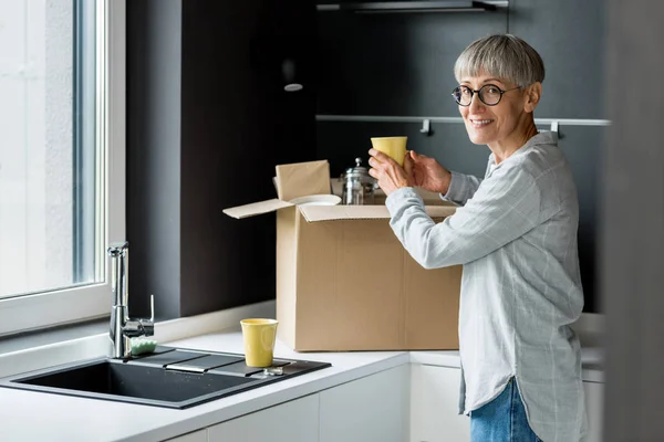 Sorridente Donna Matura Disimballaggio Scatola Nuova Casa — Foto Stock