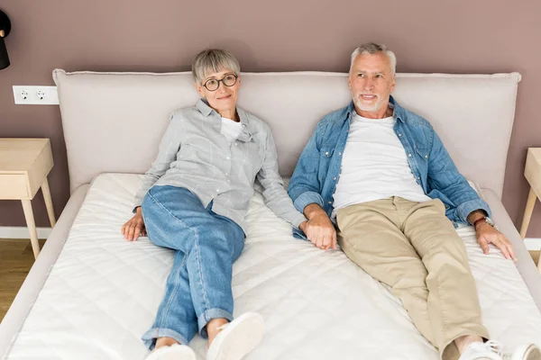 Mature Man Smiling Woman Holding Hands Bed New House — 스톡 사진