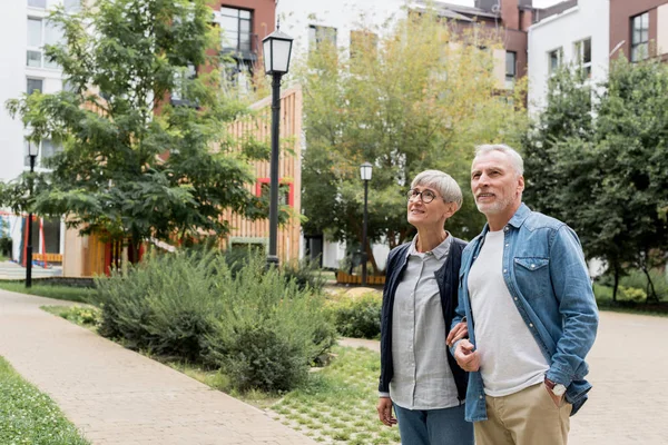 Mature Man Smiling Woman Looking Away New Buildings — 스톡 사진