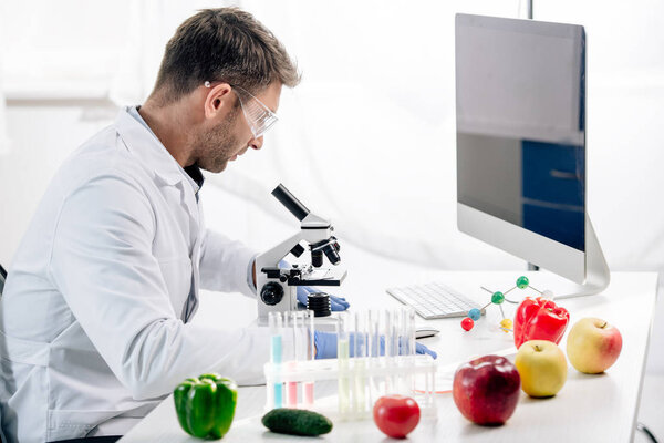 side view of molecular nutritionist using microscope in lab 