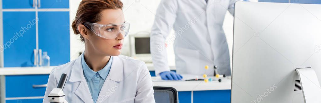 panoramic shot of attractive molecular nutritionist looking at computer