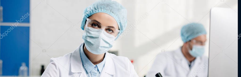 panoramic shot of genetic consultant looking at camera in lab 