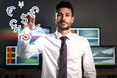 Çift ırklı tüccar para işaretlerinin yakınındaki kameraya bakıyor. 