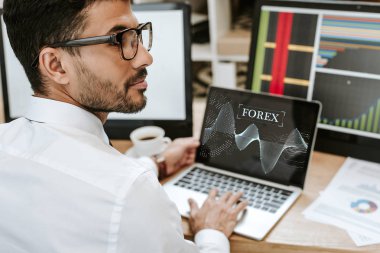 Laptopun yanında oturan çift ırklı tüccarın seçici odak noktası