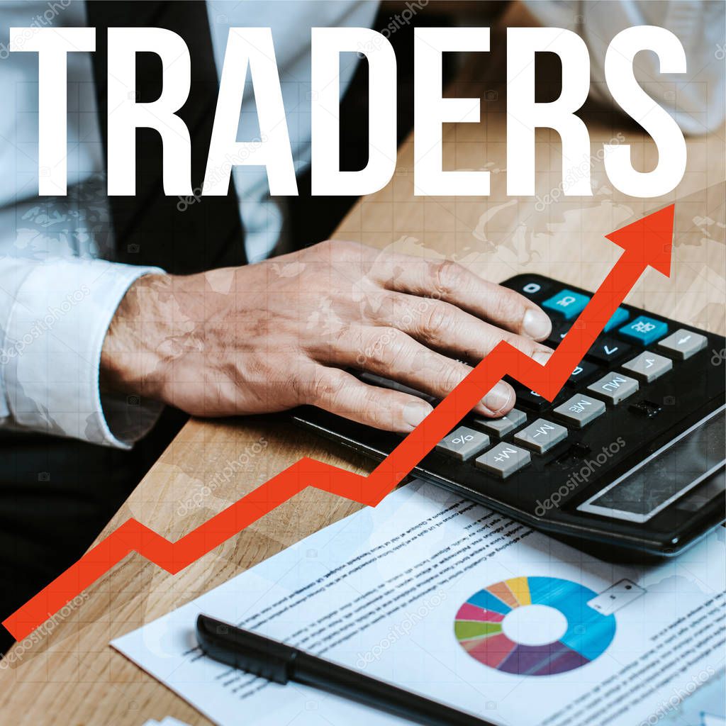 cropped view of man using calculator near traders letters