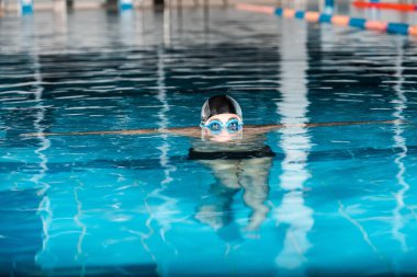 cropped view of swimmer in swimming cap and googles in water  clipart