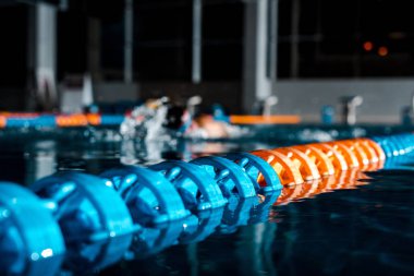 selective focus of buoys in water near swimmer  clipart