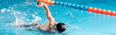 panoramic shot of handsome swimmer training in swimming pool  clipart