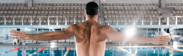 panoramic shot of swimmer standing with outstretched hands