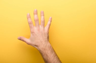 cropped view of man showing five fingers on yellow background  clipart