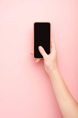 Pembe arka planda akıllı telefon tutan kadın görüntüsü 