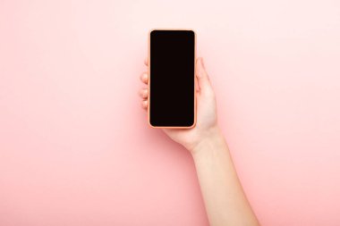 Pembe arka planda akıllı telefon tutan kadın görüntüsü 