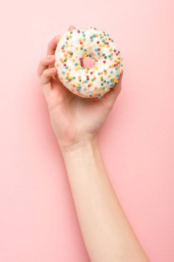 Kırpılmış pembe arka planda donut tutan kadın manzarası 