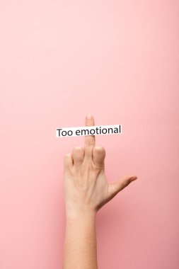 cropped view of woman showing middle finger and card with too emotional lettering on pink background  clipart
