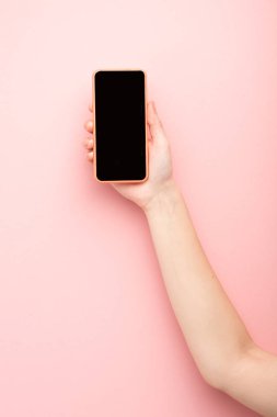 Pembe arka planda akıllı telefon tutan kadın görüntüsü 