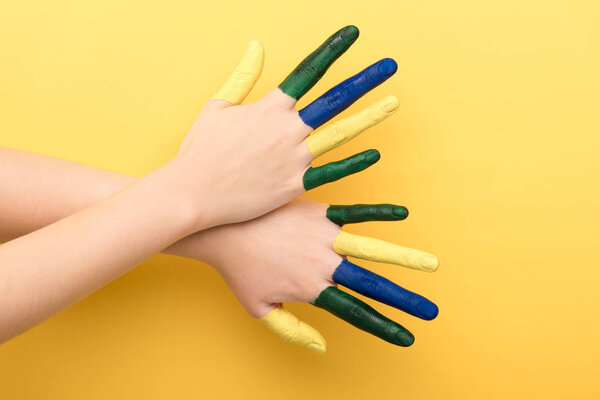 cropped view of woman showing colorful fingers on yellow background 