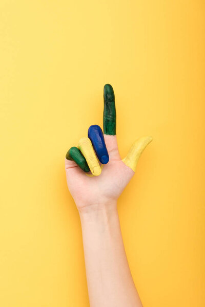 cropped view of woman with colorful fingers showing idea gesture isolated on yellow 