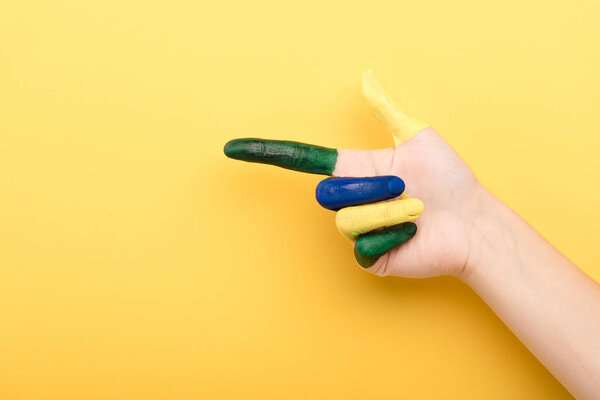 cropped view of woman pointing with finger on yellow background 