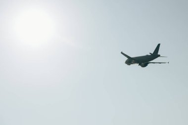 Low angle view of aeroplane in clear sky with sun clipart