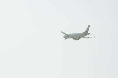 Bulutlu havada havalanan jet uçağının alçak açılı görüntüsü 