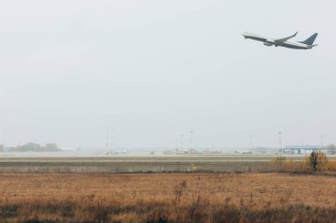 Flight departure of plane on airfield with cloudy sky at background clipart