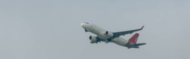 Panoramic shot of airplane in cloudy sky clipart