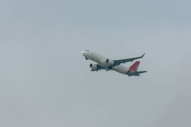 Bulutlu gökyüzünde alçak açılı jet uçağı görüntüsü