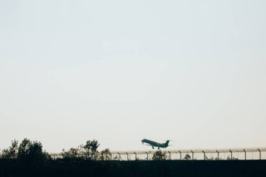 Gün batımında havaalanı pistinde bir jet uçağı