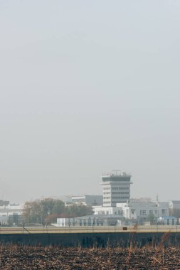 Havaalanında pist ve bulutlu gökyüzü olan havaalanı binaları