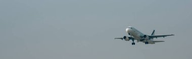 Departure of jet plane in cloudy sky, panoramic shot with copy space clipart