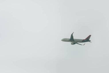 Low angle view of flight departure of plane in cloudy sky  clipart