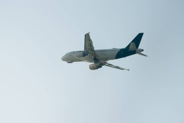 Arka planda açık gökyüzü olan uçağın alçak açılı görüntüsü