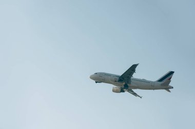 Mavi gökyüzünde alçak açılı bir jet uçağı.