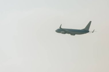 Bulutlu gökyüzünde alçak açılı bir jet uçağı.