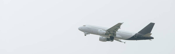 Airplane taking off in cloudy sky, panoramic shot