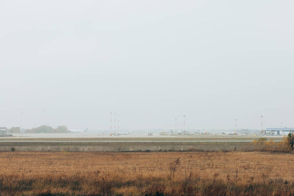 Airplanes on airfield highway with cloudy sky at background