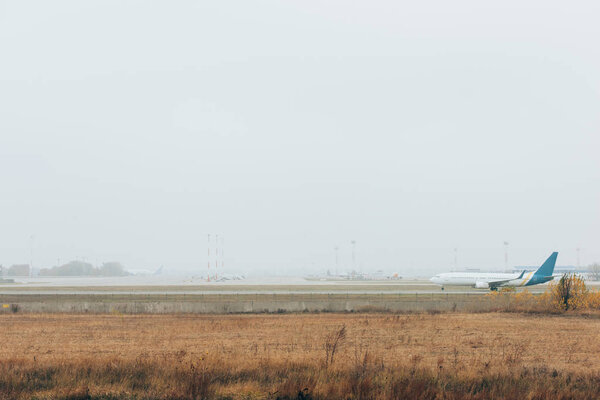 Самолет на взлетно-посадочной полосе с самолетами на шоссе
